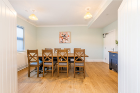 Dining room at Church Road with a wooden table and chairs and sage green walls