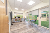 Bright classroom with large floor to ceiling windows looking out onto a green garden