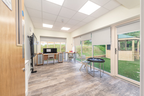 Bright classroom with large floor to ceiling windows looking out onto a green garden