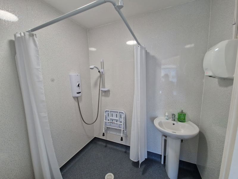 Accessible wet room at Chesterwood with a level-access shower, shower seat and basin