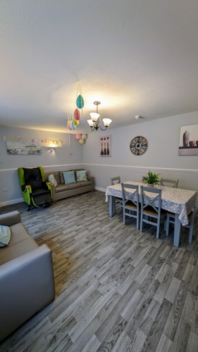 Lounge and dining area at Cedar House with sofas, a dining table and wall clock