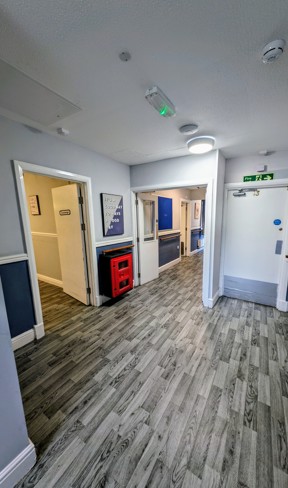 Hallway at Cedar House leading to the lounge with grey wood-effect flooring