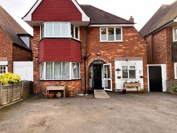 Front exterior of Chesterwood, a red-brick house with a tiled bay window and white porch