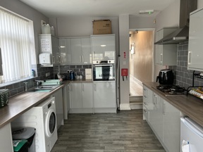 Kitchen at Thompson Court with grey gloss units, a gas hob, oven and wood-effect flooring