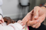 Newborn baby's hand gripping an adult's finger at Clairmont family assessment centre